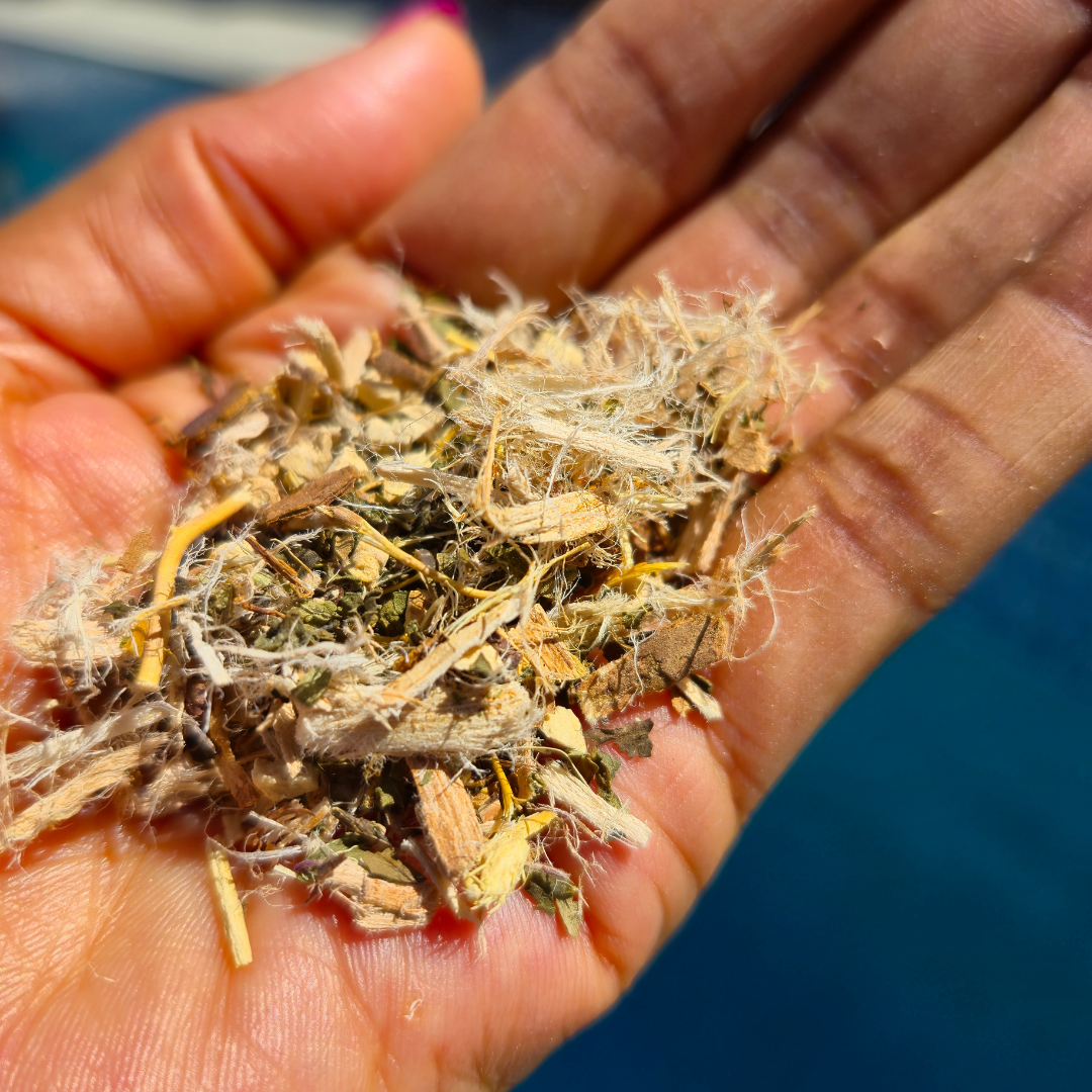 Hand holding a small pile of dried herbs or plants Kind Gut