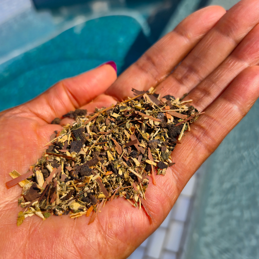 Hand holding a small amount of dried herbs with a blurred background Root Reset 